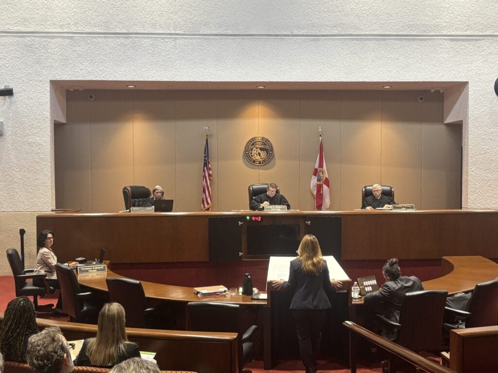 Three Justices with the Third District Court of Appeals of Florida sitting behind the bench in a courtroom.